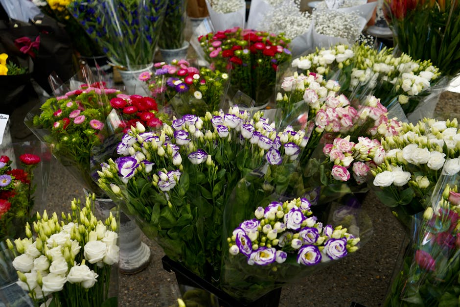 An array of fresh flower bouquets arranged on a display table at hollandparkflowers.co.uk, featuring various floral varieties such as white lisianthus, purple and white irises, pink and white carnatio